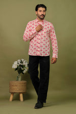 Load image into Gallery viewer, Man wearing a white and pink elephant printed full sleeve shirt with black jeans against an olive green background.